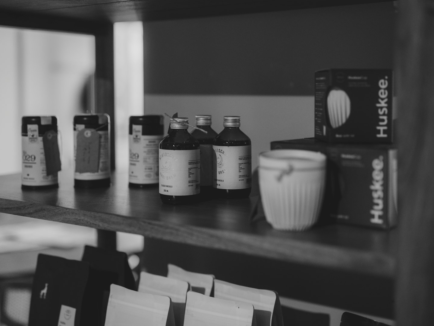 Nowoczesne produkty detaliczne wyeksponowane na ciemnych drewnianych półkach w sklepie.